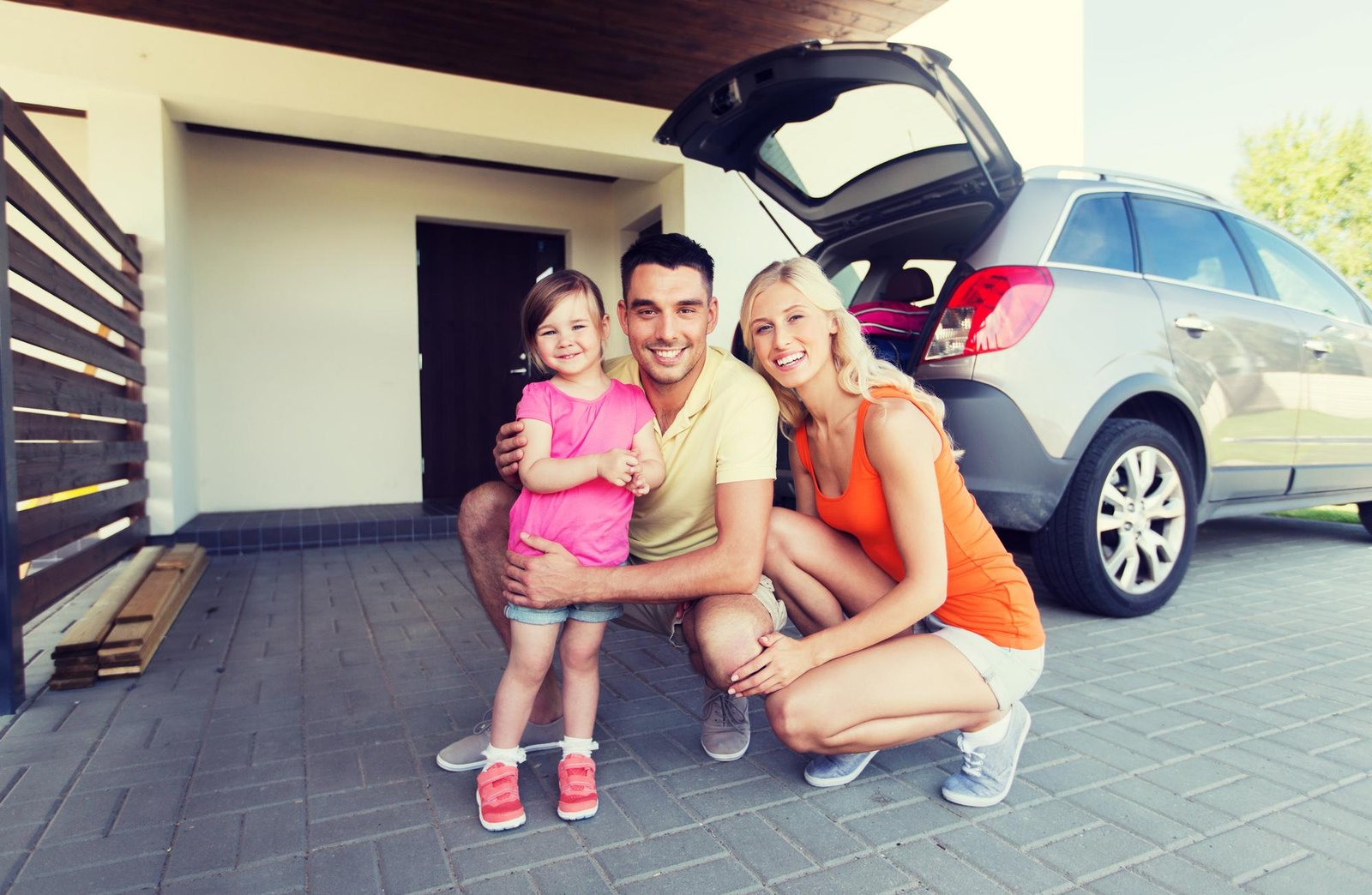 Ohio family standing by their car, thinking about how much car insurance they need