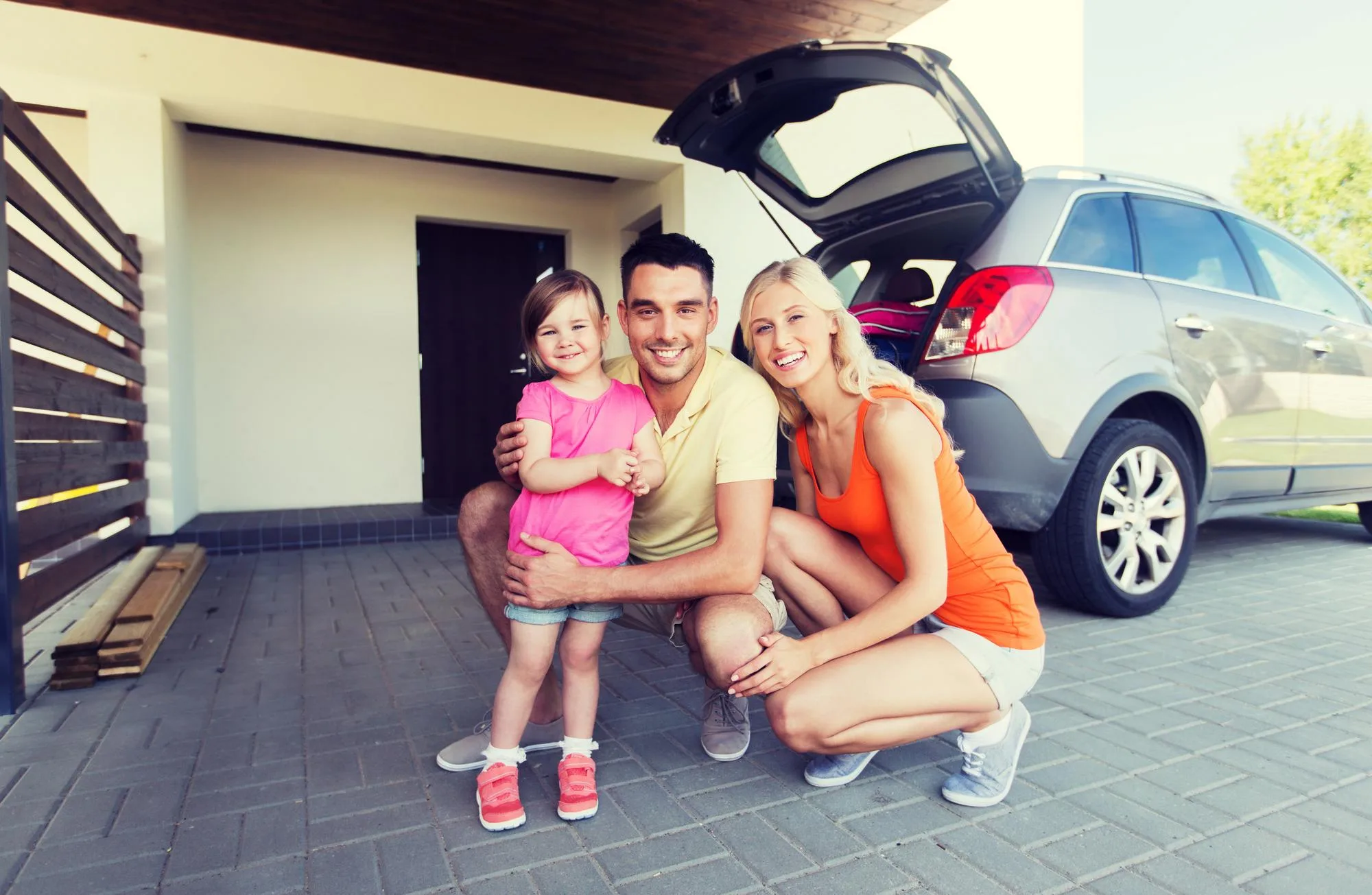 Ohio family standing by their car, thinking about how much car insurance they need